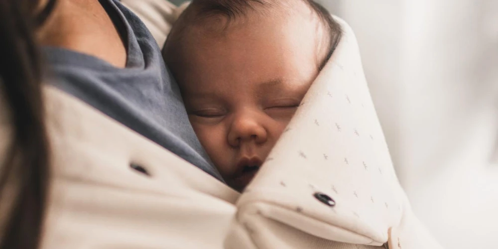 baby sleeping in babywearing