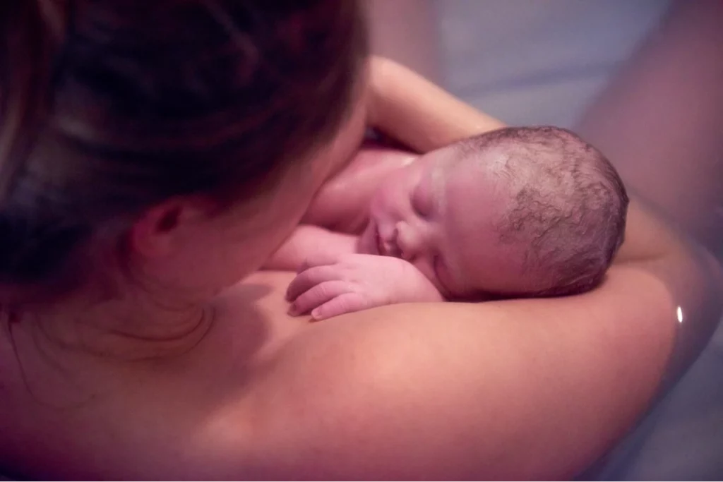 over-shoulder-portrait-of-young-woman-holding-new-baby